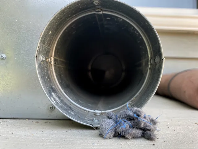 Central Falls Dryer Vent Cleaning technician using specialized equipment to clear severe dryer vent blockage in Central Falls